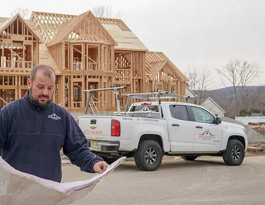 Pasquale “Pat” Conturso of Mountaintop Construction reading blueprints at a build site