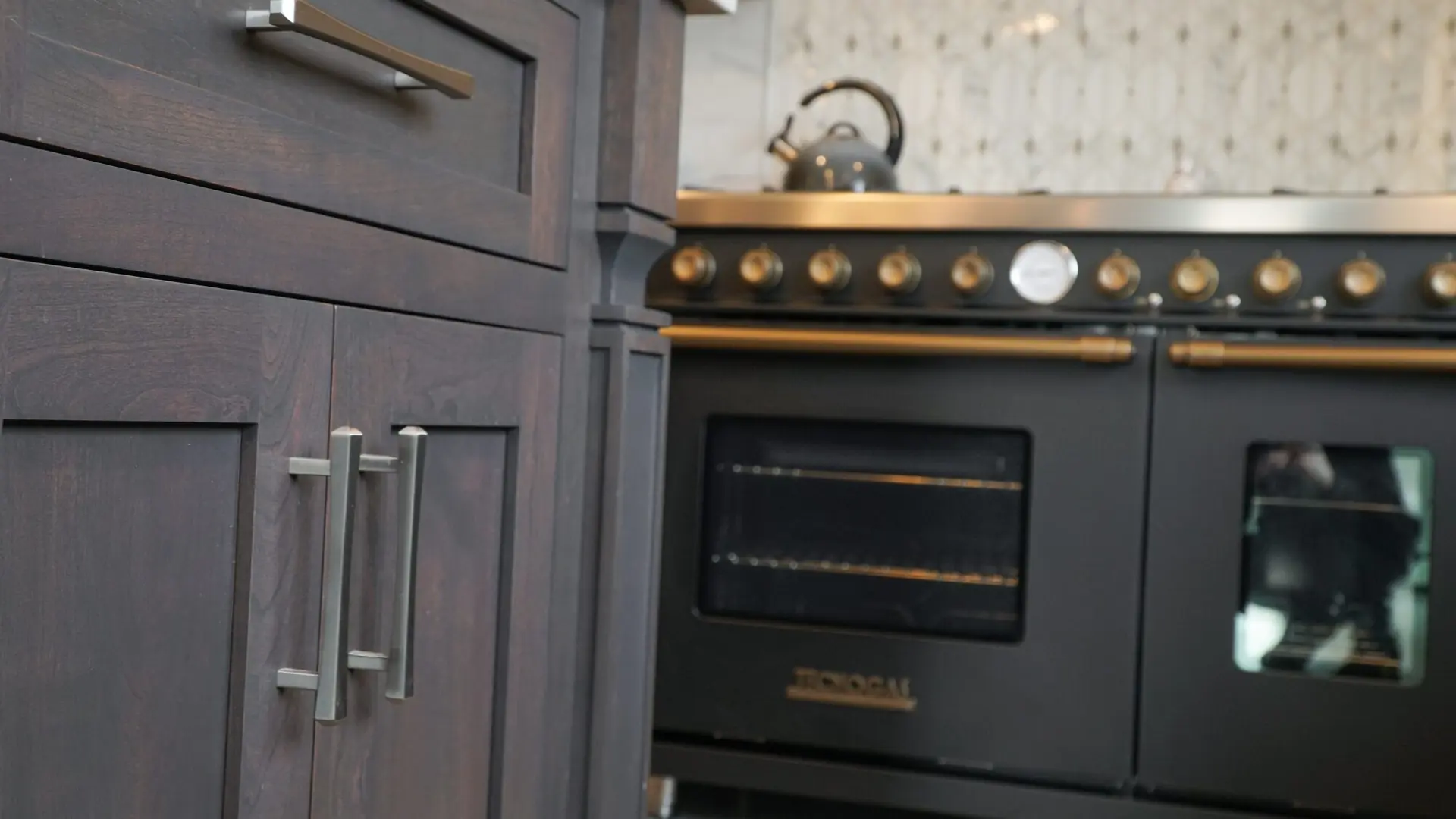 Dark shaker cabinetry beside a professional range